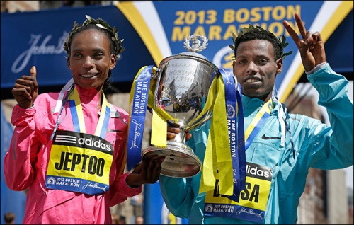 Rita Jeptoo of Kenya and Lelisa Desisa of Ethiopia pose with a trophy at the finish line after winning the women's and men's divisions of the 2013 Boston Marathon in Boston Monday, April 15, 2013. (AP Photo/Elise Amendola)